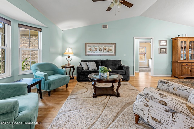 living room featuring ceiling fan, lofted ceiling, and light wood-type flooring