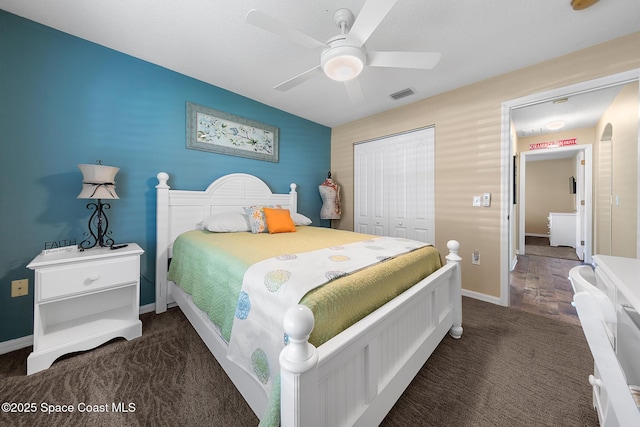 bedroom featuring ceiling fan, dark carpet, and a closet