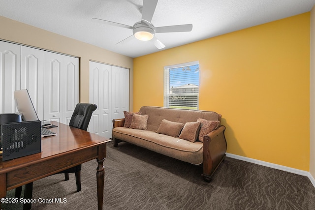 carpeted home office featuring a textured ceiling and ceiling fan