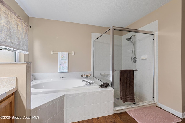 bathroom with vanity, hardwood / wood-style floors, independent shower and bath, and a textured ceiling