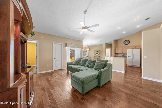 living room featuring hardwood / wood-style flooring, lofted ceiling, a textured ceiling, and ceiling fan