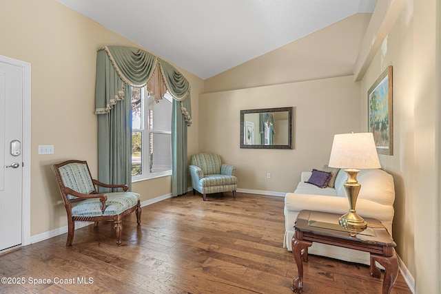 living area featuring hardwood / wood-style flooring and vaulted ceiling