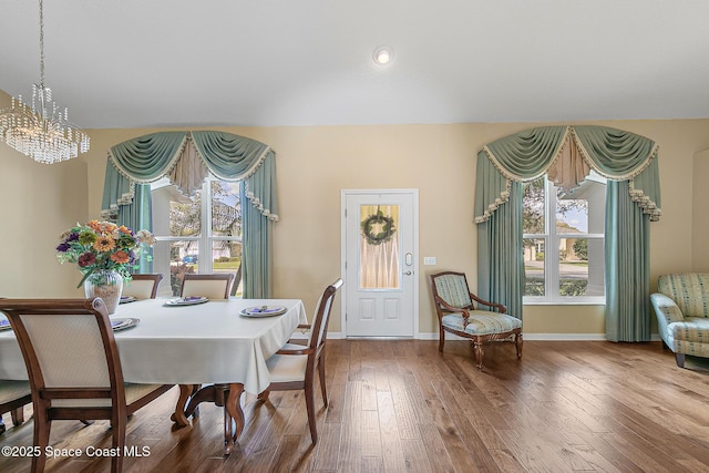 dining area featuring hardwood / wood-style flooring and a notable chandelier