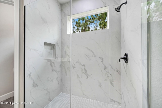 bathroom featuring a marble finish shower