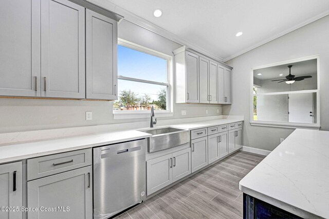 kitchen featuring light wood finished floors, dishwasher, ornamental molding, a sink, and recessed lighting