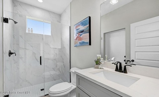 full bathroom featuring toilet, a marble finish shower, and vanity