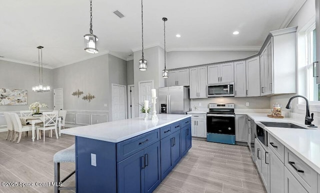 kitchen with stainless steel appliances, crown molding, wood finish floors, light countertops, and a sink