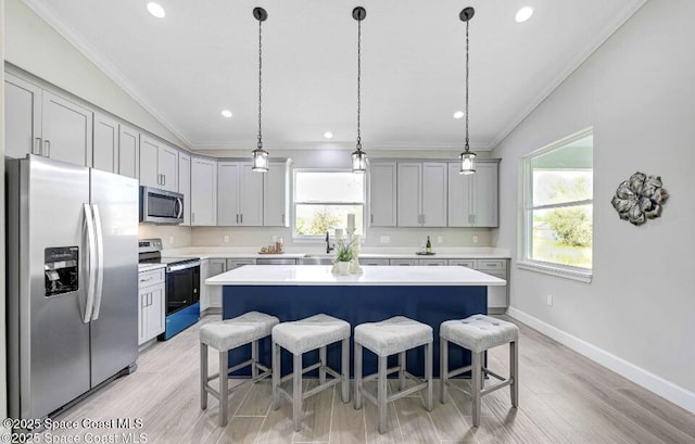 kitchen featuring a breakfast bar, vaulted ceiling, stainless steel appliances, and light countertops