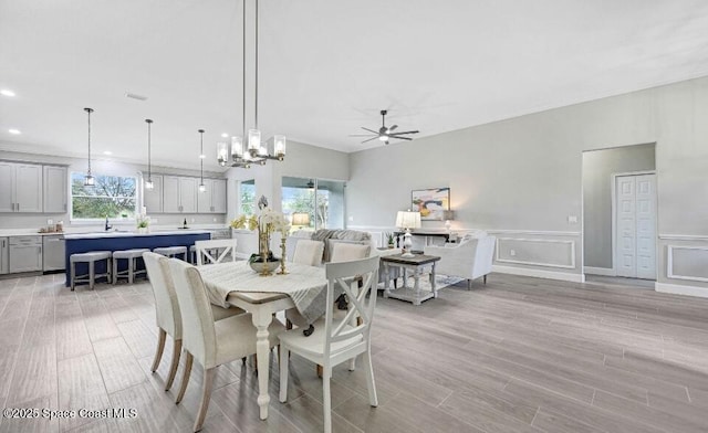 dining area with a wainscoted wall, ceiling fan, light wood-style floors, a decorative wall, and recessed lighting