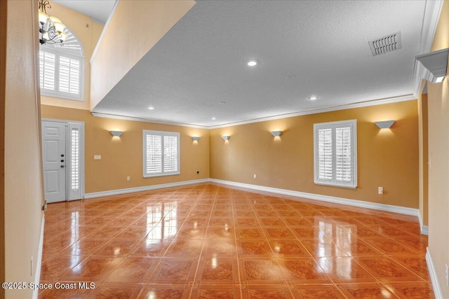 interior space featuring crown molding, a textured ceiling, and a wealth of natural light