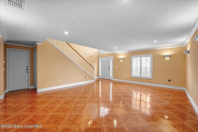 interior space with ornamental molding and a textured ceiling