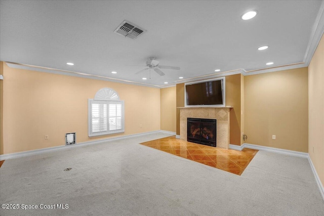 unfurnished living room featuring light carpet, crown molding, a premium fireplace, and ceiling fan