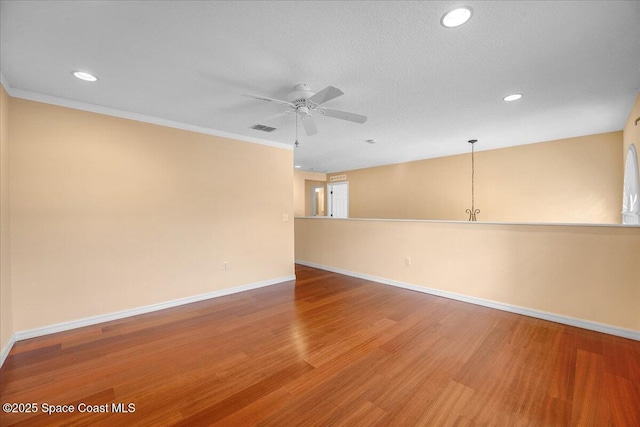 spare room featuring hardwood / wood-style floors, crown molding, a textured ceiling, and ceiling fan