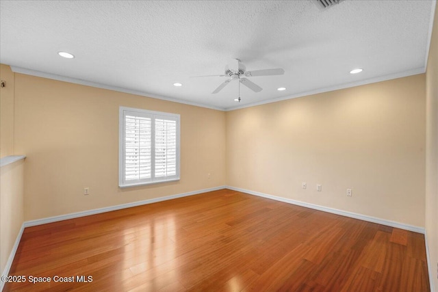 empty room with wood-type flooring, crown molding, ceiling fan, and a textured ceiling