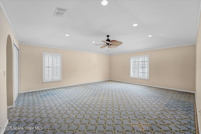 spare room with crown molding, ceiling fan, plenty of natural light, and light colored carpet