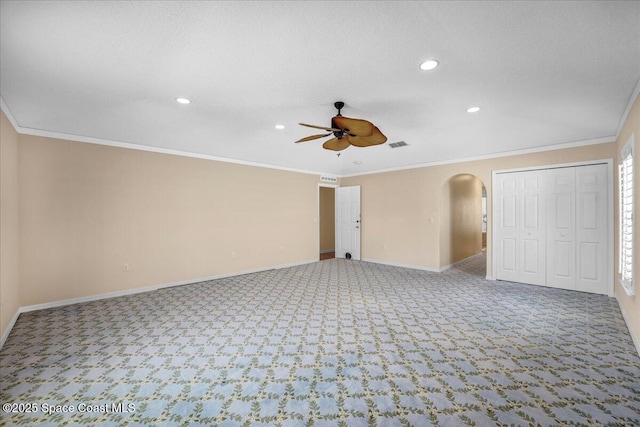 unfurnished bedroom with light carpet, a textured ceiling, ornamental molding, a closet, and ceiling fan