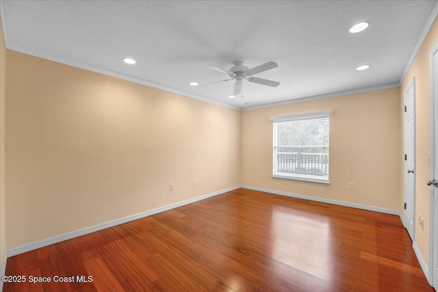 empty room featuring hardwood / wood-style flooring, crown molding, and ceiling fan