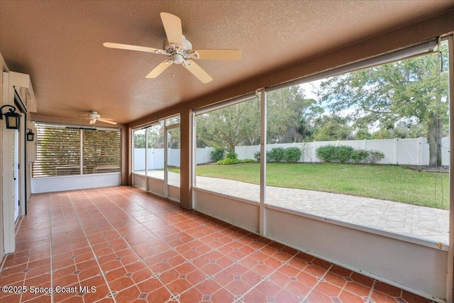 unfurnished sunroom with ceiling fan