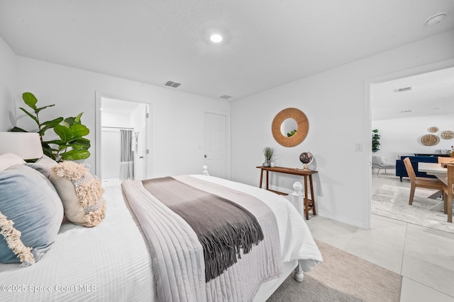 bedroom featuring light tile patterned flooring, visible vents, and baseboards