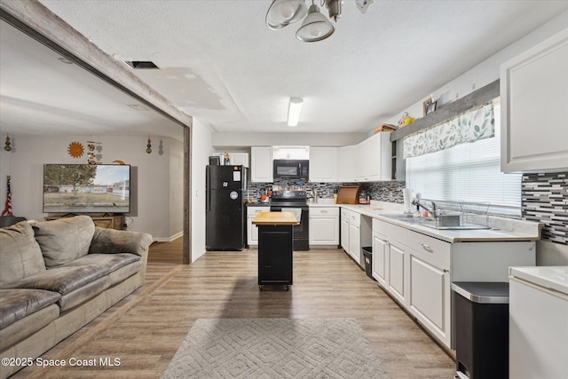 kitchen featuring white cabinetry, black appliances, and a kitchen island