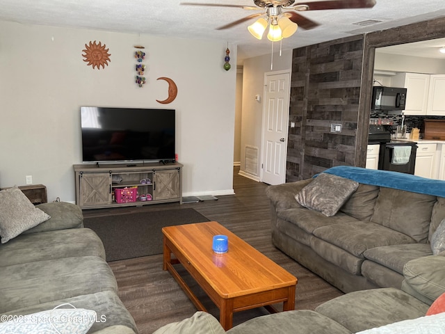 225 Court St, Titusville, FL 32780 - living area featuring a ceiling fan, wood finished floors, baseboards, and a textured ceiling