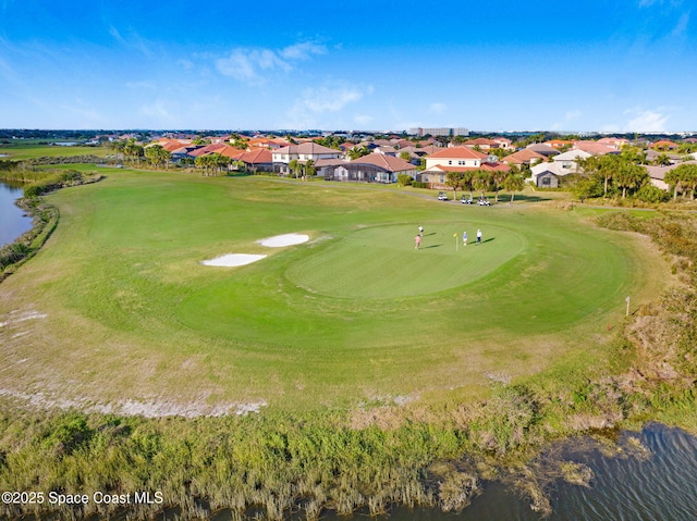 aerial view featuring a water view, view of golf course, and a residential view