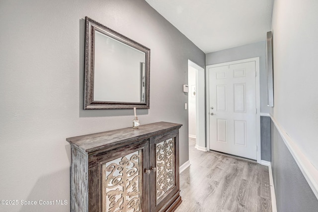 foyer entrance with light wood finished floors and baseboards