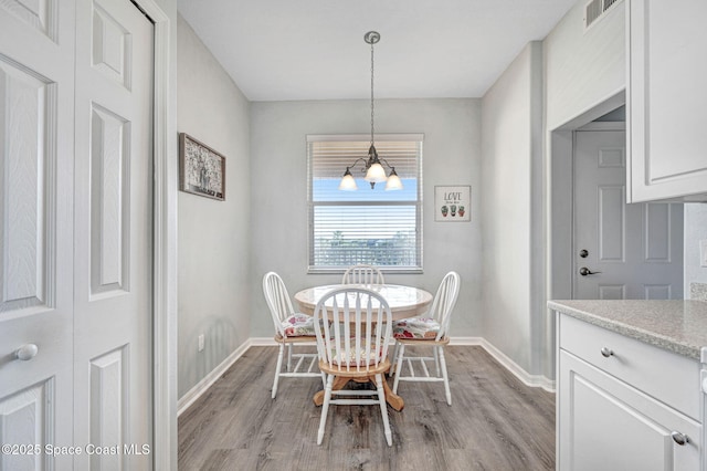 dining area featuring baseboards, visible vents, and light wood-style floors