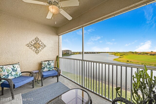 balcony featuring a water view and ceiling fan