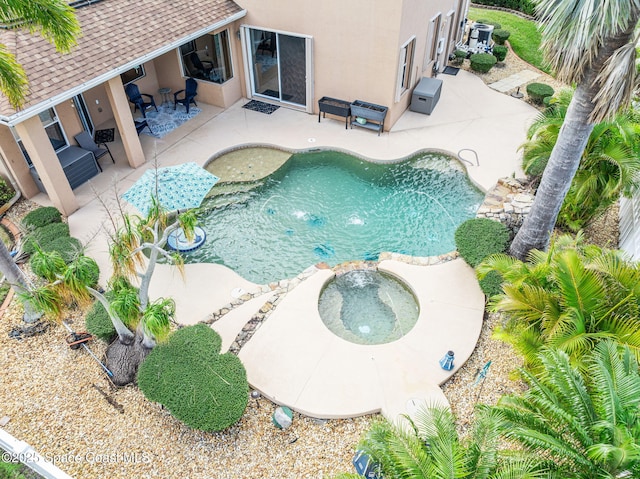 outdoor pool featuring a patio and an in ground hot tub