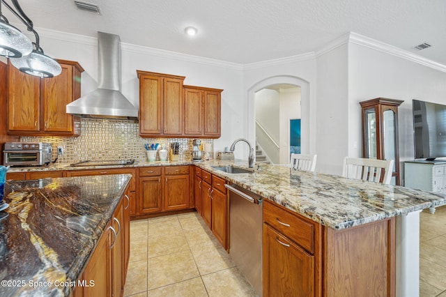 kitchen featuring a toaster, wall chimney exhaust hood, visible vents, dishwasher, and a kitchen breakfast bar