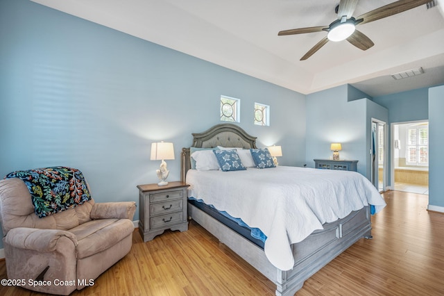 bedroom featuring baseboards, visible vents, ceiling fan, and light wood finished floors