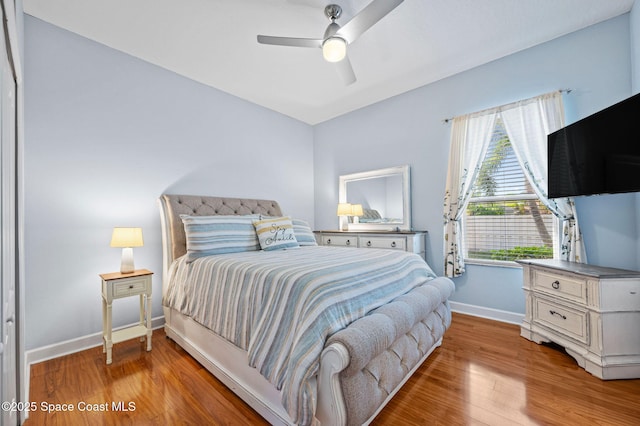 bedroom with baseboards, a ceiling fan, and light wood-style floors