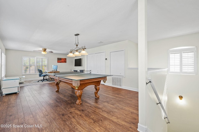 recreation room with a ceiling fan, visible vents, baseboards, and hardwood / wood-style flooring