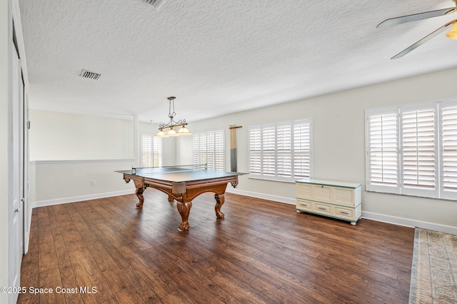 recreation room with a healthy amount of sunlight, ceiling fan, visible vents, and dark wood-style flooring