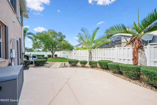 view of patio / terrace featuring glass enclosure and a fenced backyard