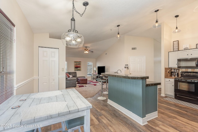 kitchen featuring white cabinetry, decorative light fixtures, dark wood-type flooring, and black appliances