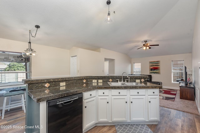 kitchen with pendant lighting, dishwasher, a center island with sink, and white cabinets