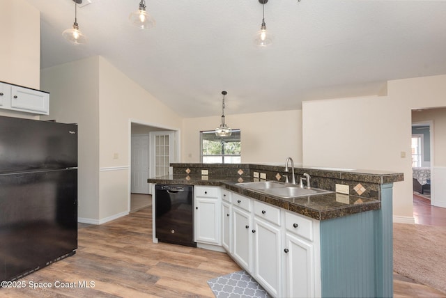 kitchen with pendant lighting, white cabinets, sink, and black appliances