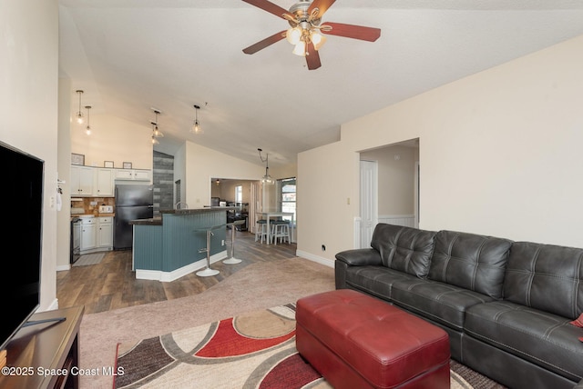 living room with vaulted ceiling, dark hardwood / wood-style floors, and ceiling fan