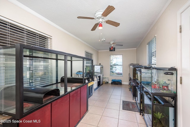 kitchen with light tile patterned floors, crown molding, and a textured ceiling