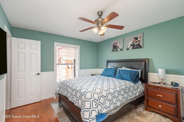 bedroom featuring a textured ceiling, light hardwood / wood-style floors, and ceiling fan