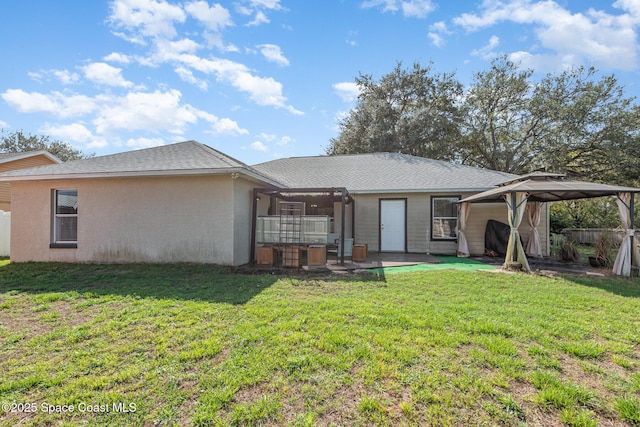 back of property with a gazebo, a yard, and a patio