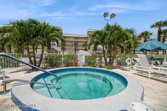 view of swimming pool with a patio area, a hot tub, and fence