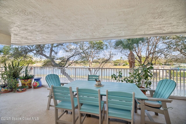 view of patio featuring a water view and outdoor dining area