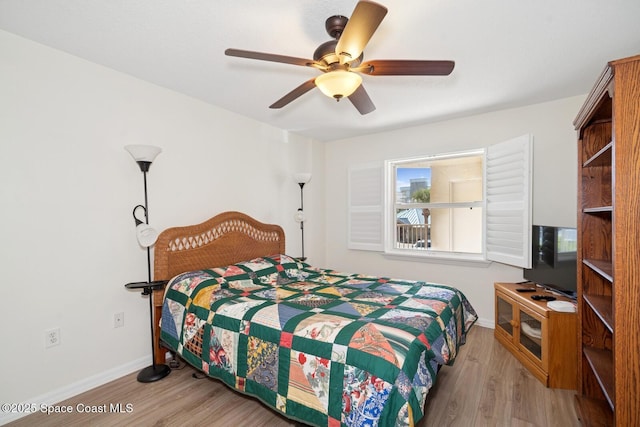 bedroom featuring a ceiling fan, baseboards, and wood finished floors