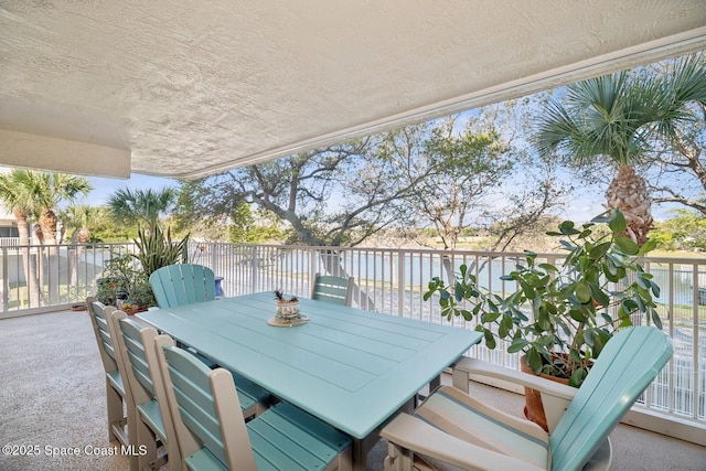 view of patio featuring a water view and outdoor dining area