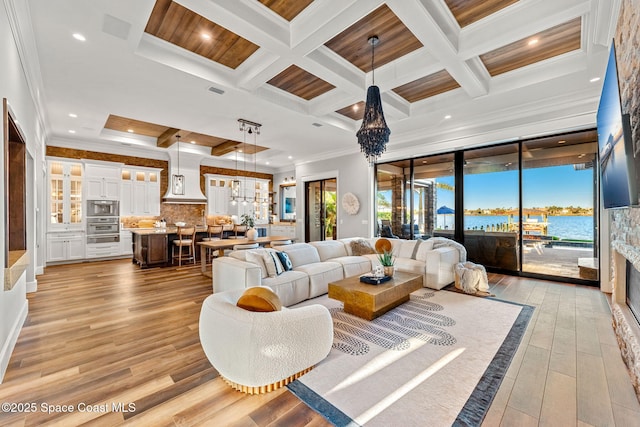 living room featuring coffered ceiling, beam ceiling, crown molding, and light hardwood / wood-style flooring