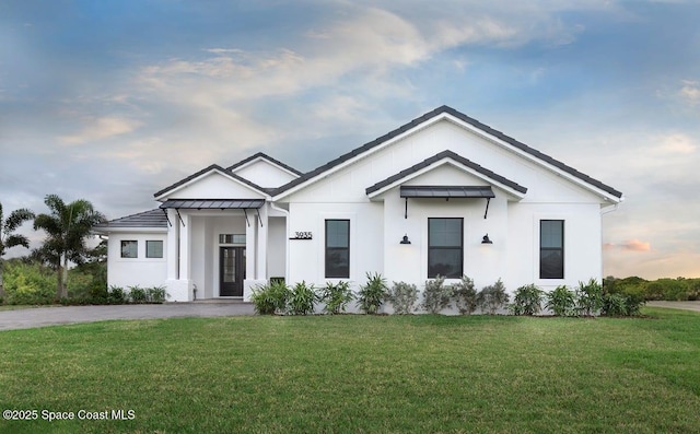 modern inspired farmhouse featuring stucco siding and a front yard