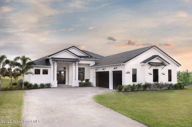 modern farmhouse style home featuring a garage and a lawn